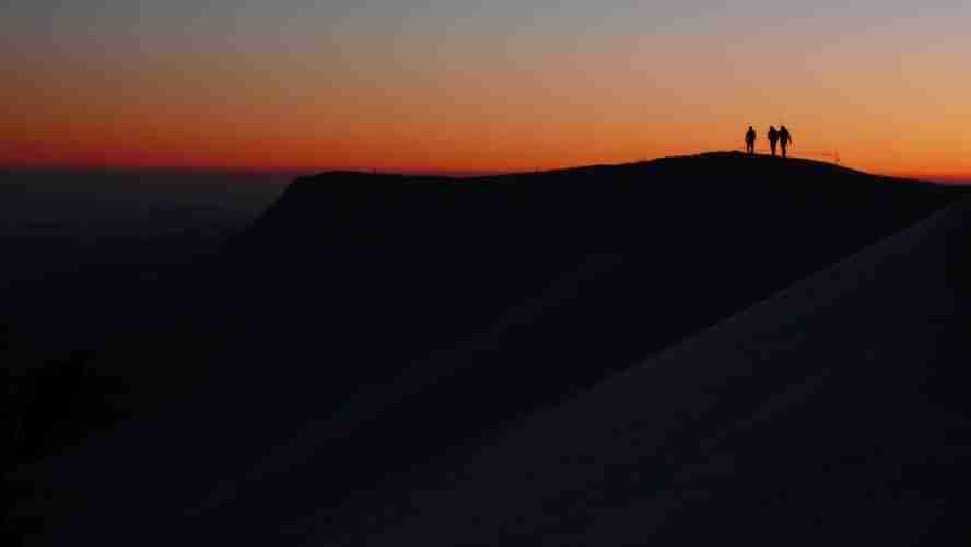 Lever de soleil au refuge du Goûter, des cordées descendent, d'autres montent au Mont-Blanc